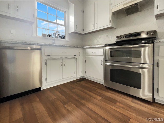 kitchen featuring white cabinets, appliances with stainless steel finishes, dark hardwood / wood-style flooring, and range hood