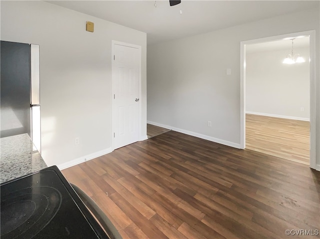 interior space with ceiling fan with notable chandelier and dark hardwood / wood-style floors