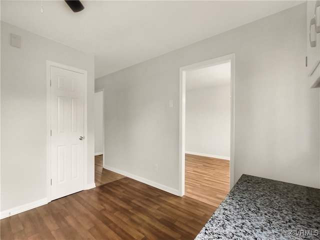 empty room featuring ceiling fan and dark wood-type flooring