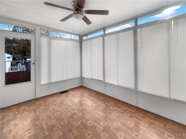 unfurnished sunroom with ceiling fan