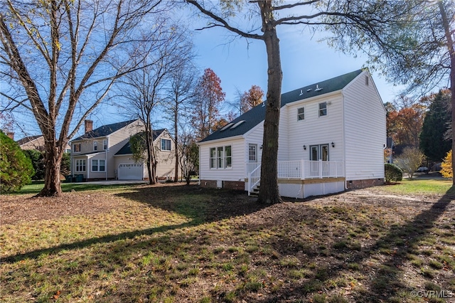 exterior space featuring a lawn, a garage, and a deck