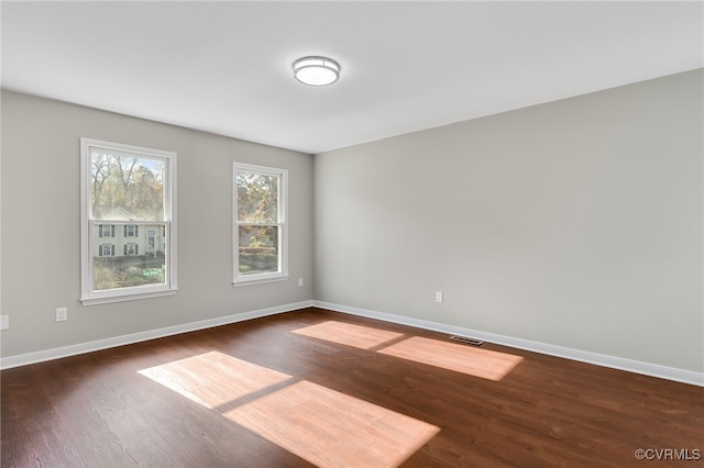 spare room featuring dark wood-type flooring