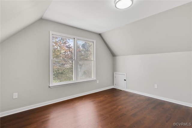 bonus room with dark hardwood / wood-style floors and vaulted ceiling