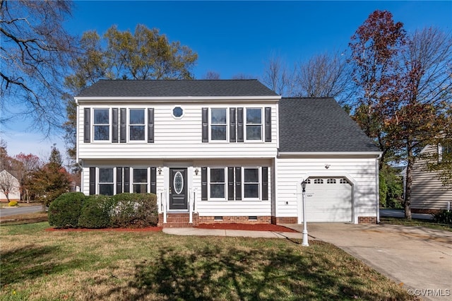 colonial inspired home with a front yard and a garage