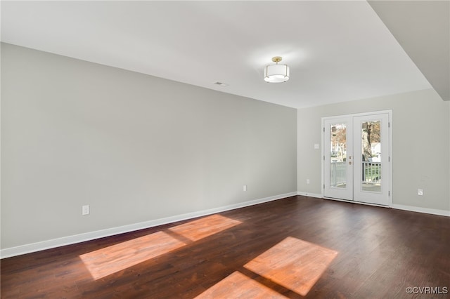 spare room featuring french doors and dark hardwood / wood-style flooring