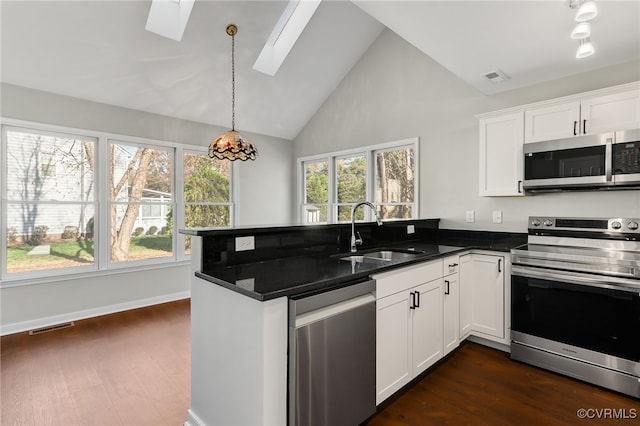 kitchen with kitchen peninsula, sink, appliances with stainless steel finishes, and a skylight