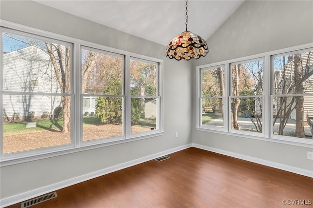 unfurnished dining area featuring hardwood / wood-style floors, lofted ceiling, and a wealth of natural light