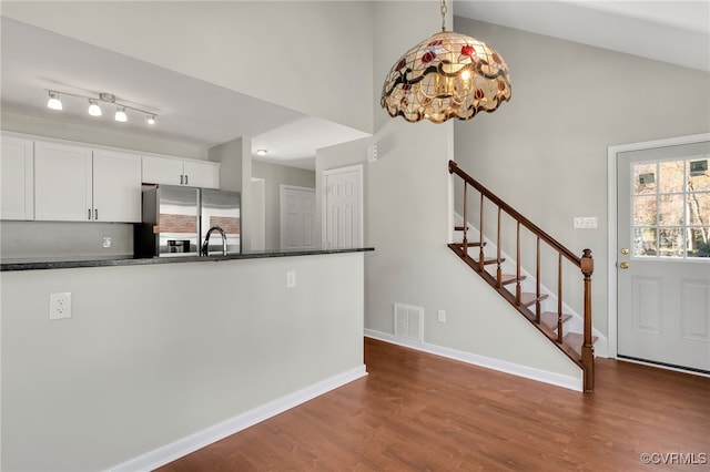 kitchen featuring white cabinets, decorative light fixtures, stainless steel fridge with ice dispenser, and dark wood-type flooring