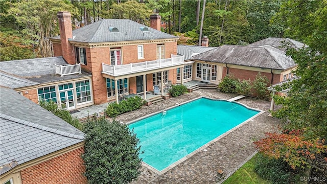 view of swimming pool with french doors, a patio, and a diving board