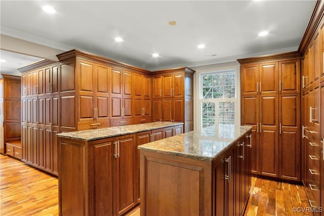 kitchen featuring light wood-type flooring, a center island, and ornamental molding