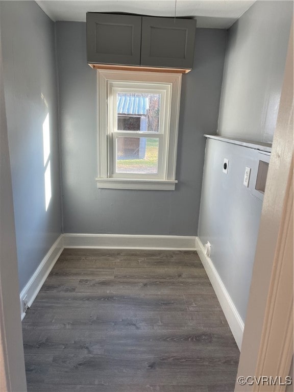 clothes washing area with electric dryer hookup and dark wood-type flooring