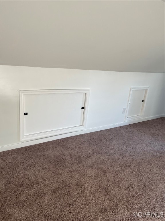 bonus room with carpet flooring and vaulted ceiling