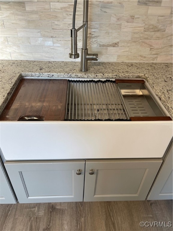 room details with light stone countertops and light hardwood / wood-style flooring