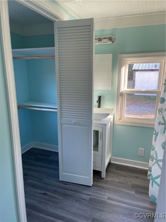 washroom with dark hardwood / wood-style flooring, ornamental molding, and sink