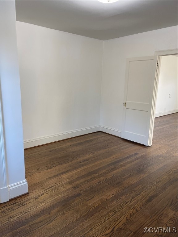 unfurnished room with dark wood-type flooring