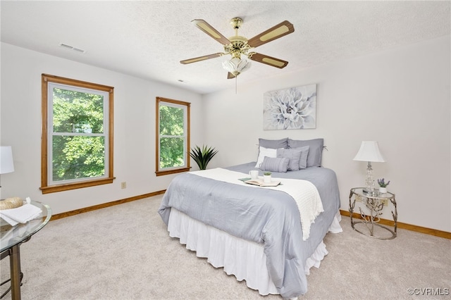 carpeted bedroom with a textured ceiling and ceiling fan