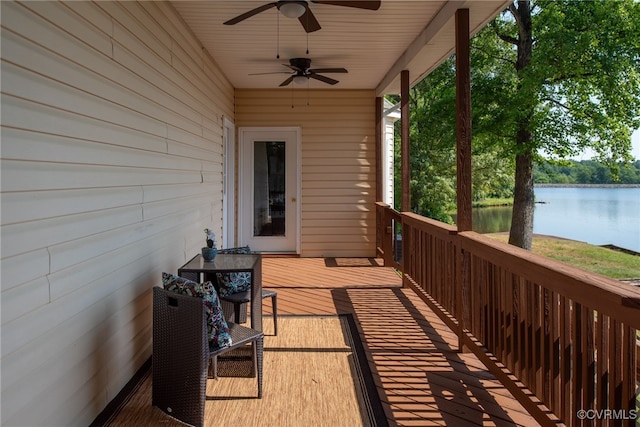 wooden terrace with a water view and ceiling fan