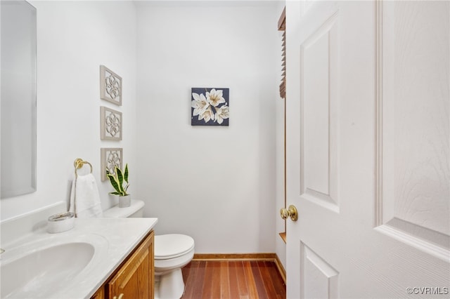 bathroom featuring vanity, hardwood / wood-style flooring, and toilet