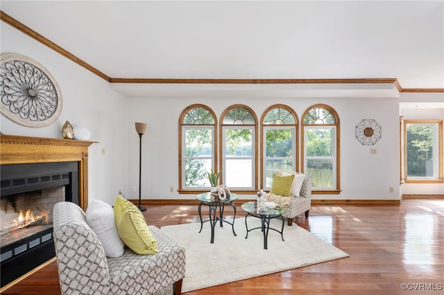 living room with a wealth of natural light, crown molding, and hardwood / wood-style flooring