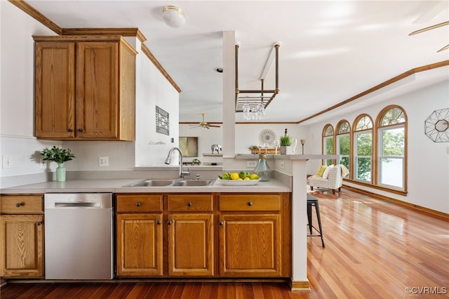 kitchen featuring backsplash, crown molding, sink, hardwood / wood-style flooring, and dishwasher