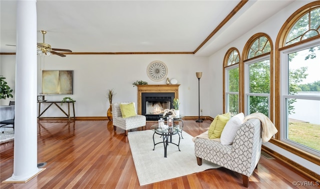 living room featuring light hardwood / wood-style floors, ornate columns, plenty of natural light, and ceiling fan