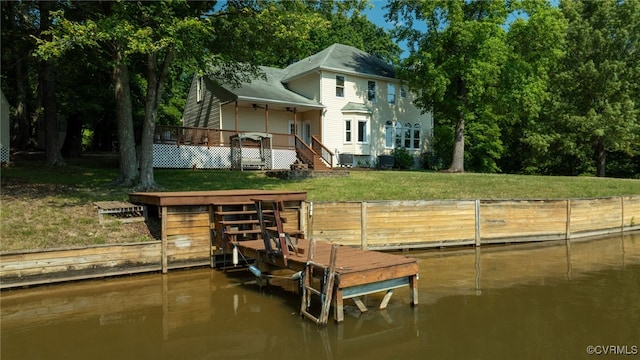 view of dock featuring a deck with water view and a yard