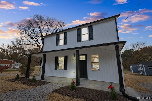 view of front facade featuring a shed and a porch