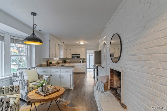 kitchen with white cabinets, stainless steel appliances, light stone countertops, and a healthy amount of sunlight