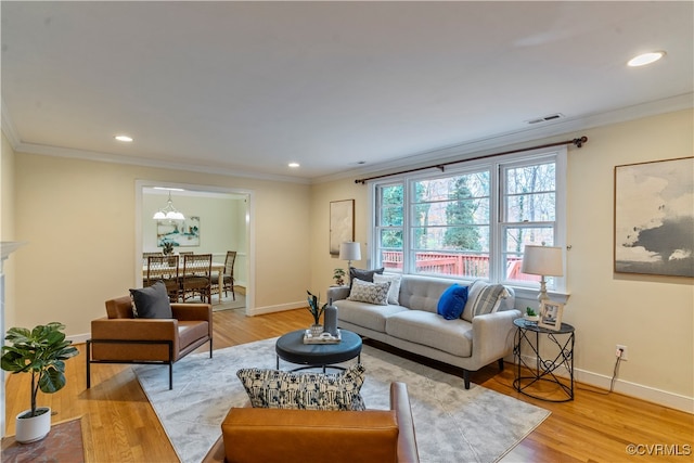 living room with light hardwood / wood-style flooring and ornamental molding