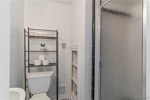 bathroom with toilet and a shower with door