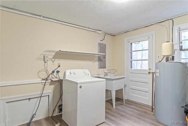 laundry room with light hardwood / wood-style floors, washer / dryer, a wealth of natural light, and water heater