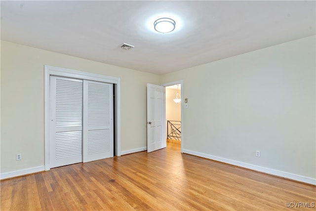 unfurnished bedroom featuring a closet and light wood-type flooring