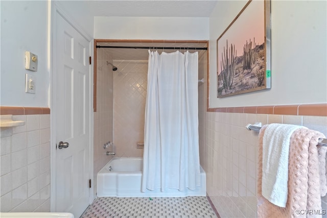 bathroom featuring shower / bath combination with curtain and tile walls