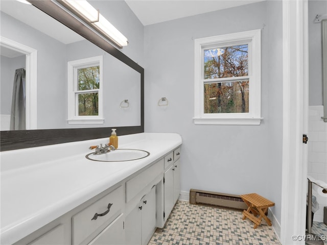 bathroom with a wealth of natural light, vanity, and a baseboard heating unit