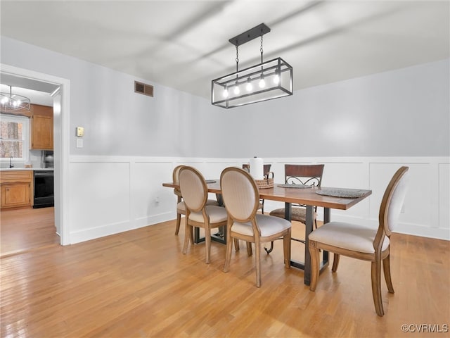 dining space featuring light hardwood / wood-style flooring and sink