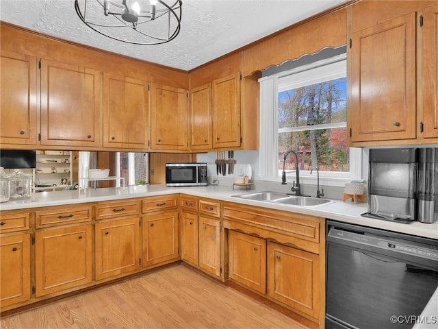 kitchen featuring a textured ceiling, sink, a notable chandelier, dishwasher, and light hardwood / wood-style floors