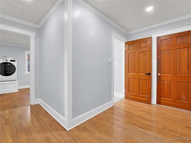 foyer entrance featuring ornamental molding, washer / clothes dryer, and light hardwood / wood-style floors