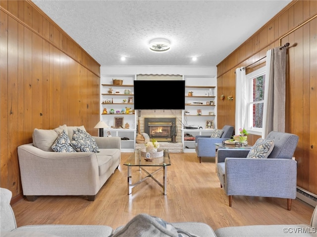 living room with light wood-type flooring, a textured ceiling, wooden walls, and a baseboard radiator