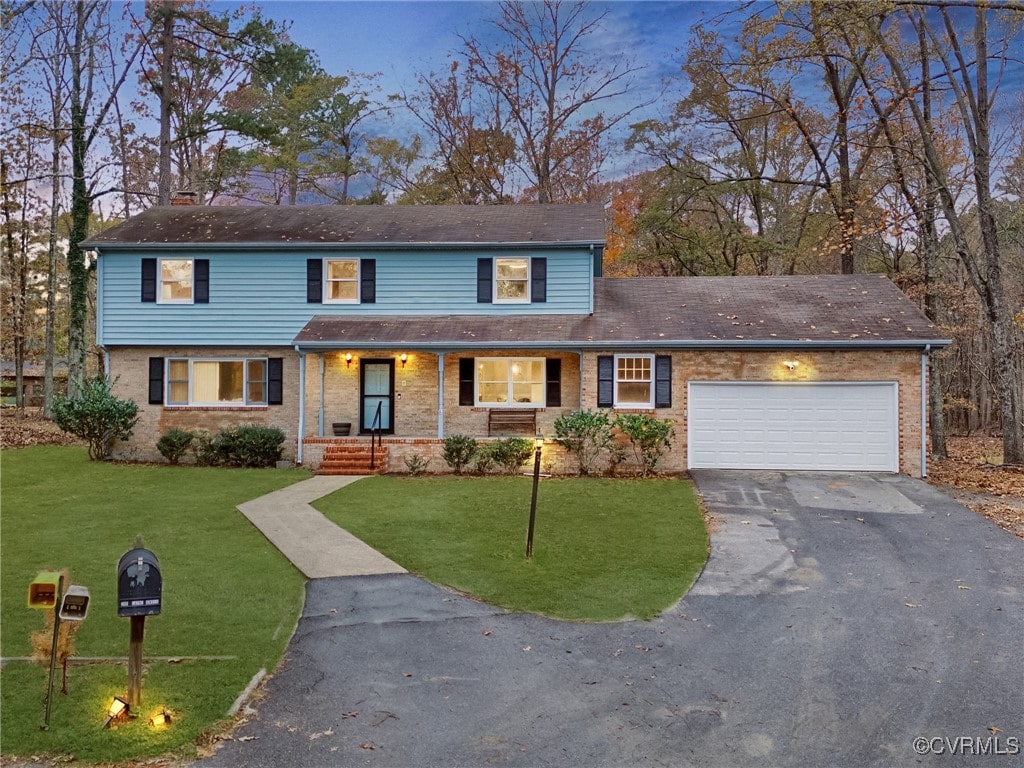 front facade featuring a garage and a lawn