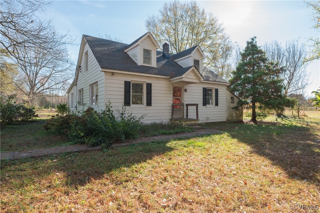 cape cod home with a front lawn