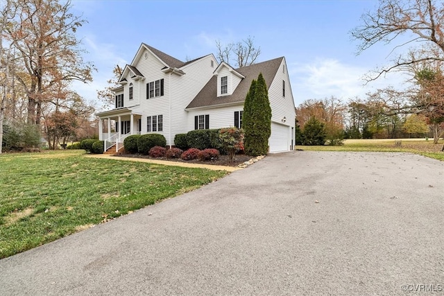 view of front of property featuring a front yard, a porch, and a garage