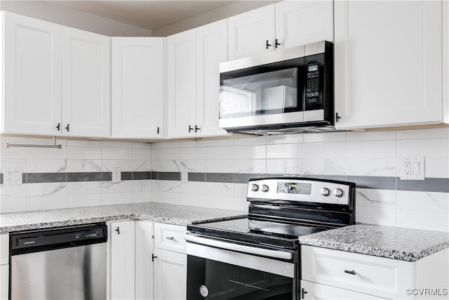 kitchen featuring white cabinetry, appliances with stainless steel finishes, light stone countertops, and tasteful backsplash