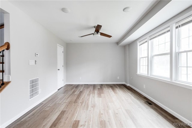 empty room with ceiling fan and light hardwood / wood-style floors