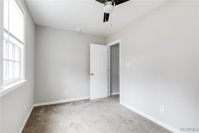 carpeted spare room with ceiling fan