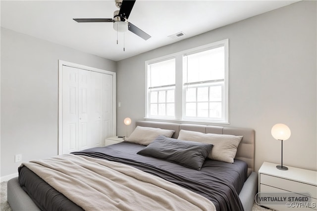 bedroom with ceiling fan, carpet floors, and a closet