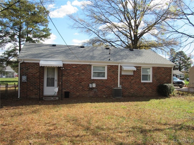 back of house featuring a lawn and central AC unit