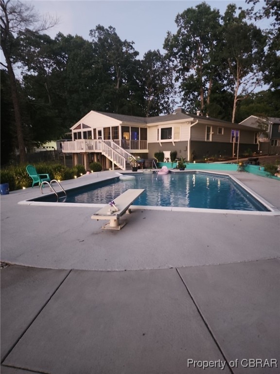 view of pool featuring a diving board