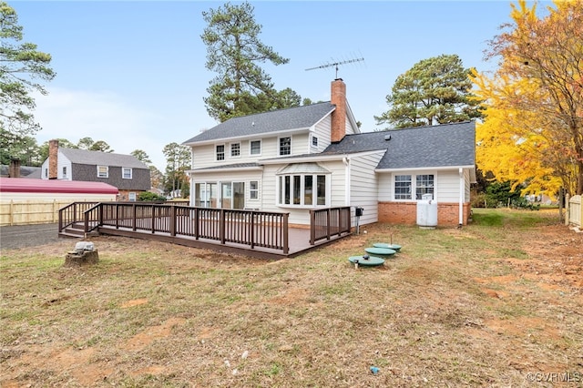 rear view of house featuring a yard and a wooden deck