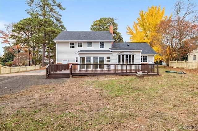 rear view of house with a deck and a yard