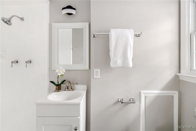 bathroom featuring a tile shower and vanity